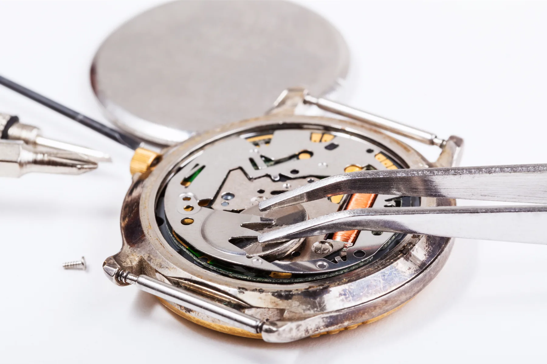 Batteriewechsel an einer Uhr, Nahaufnahme mit Pinzette